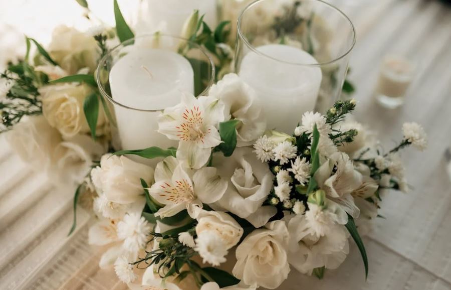White roses and soft blooms around glass candles, cremation services Clearwater, FL