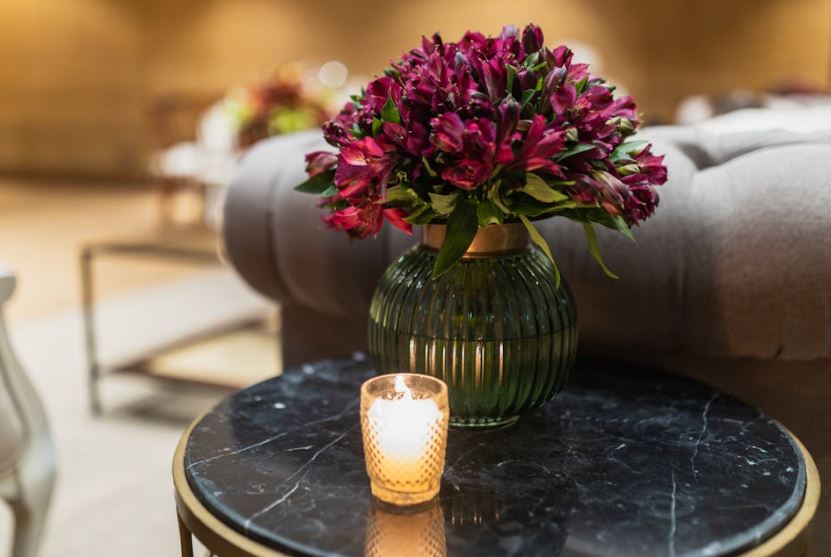 Candlelit side table with deep purple flowers, cremation arrangements, cremation services St. Petersburg, FL