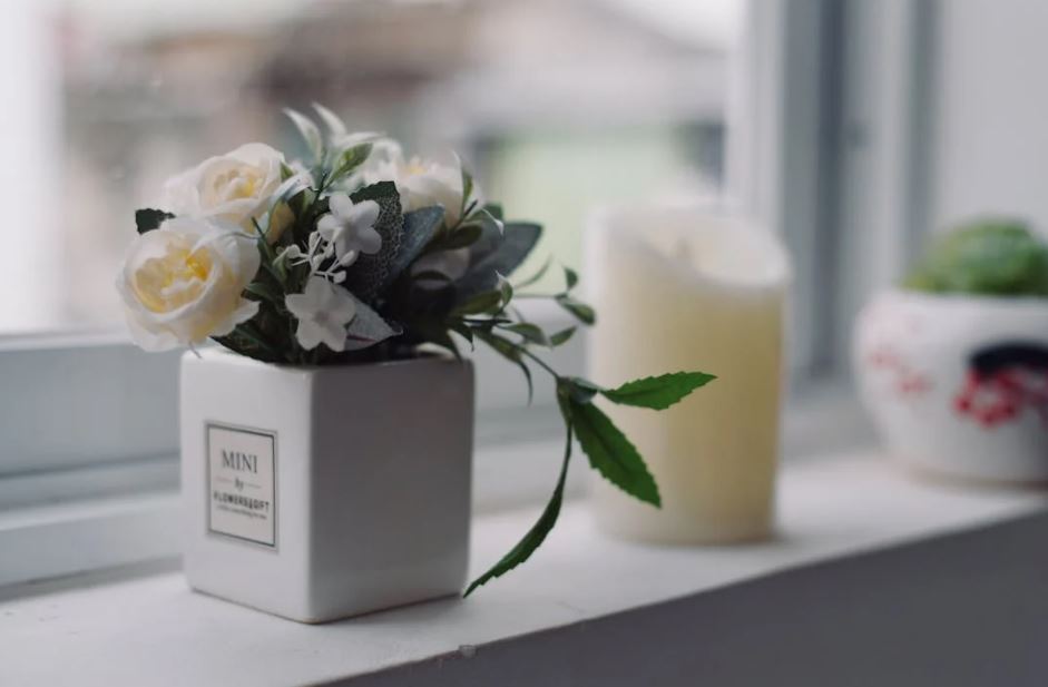 Small flower pot on windowsill with candle, direct cremation smart choice, cremation services Largo, FL