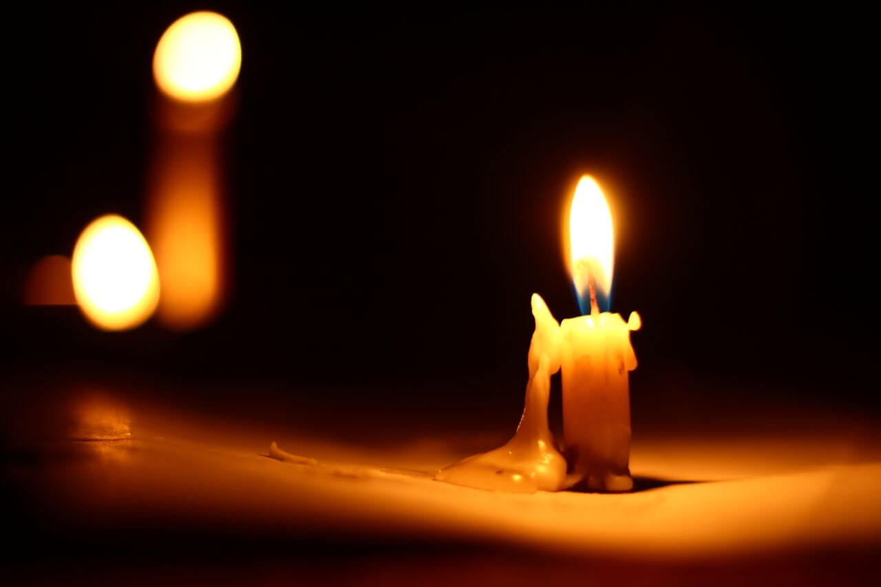 Lighted memorial candle with soft glow on dark background representing remembrance and Largo, FL cremation services